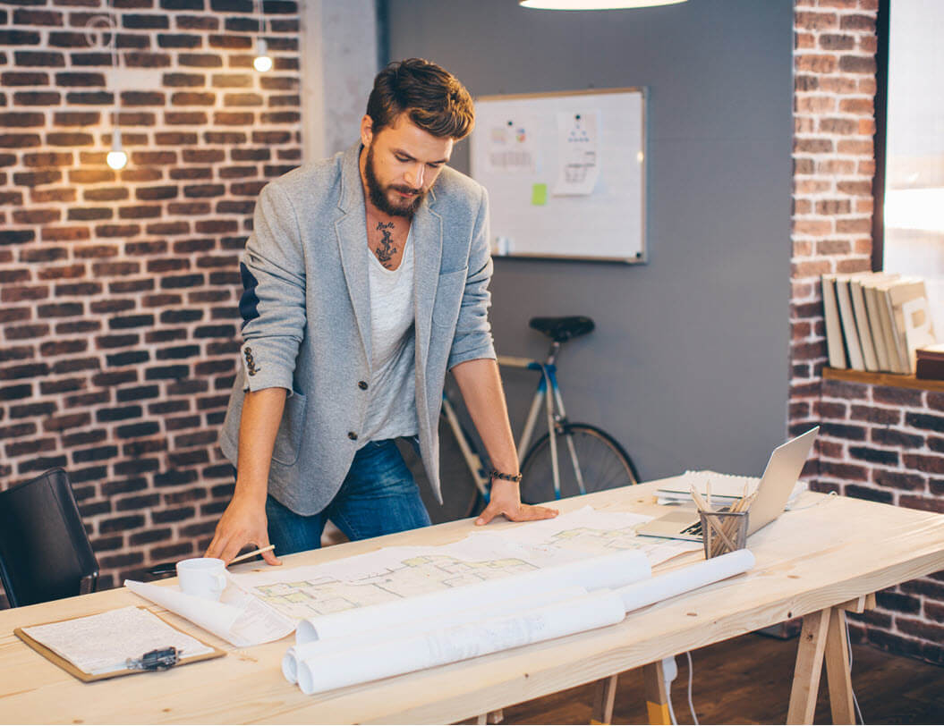 business man looking at plans on a desk