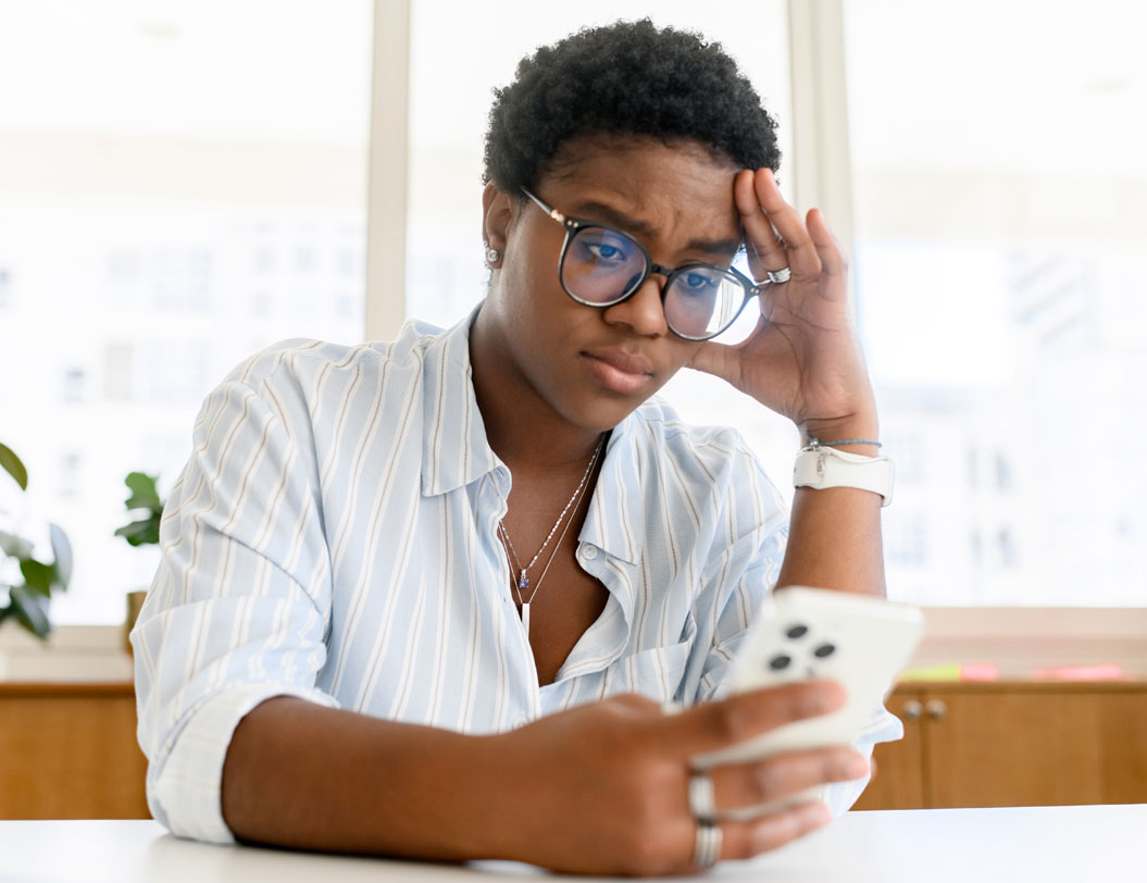 Woman looking at mobile phone with stressed look