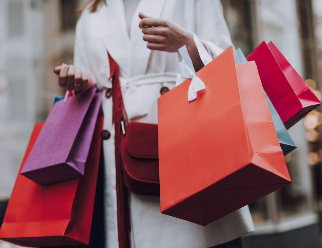 Woman carrying many different shopping bags