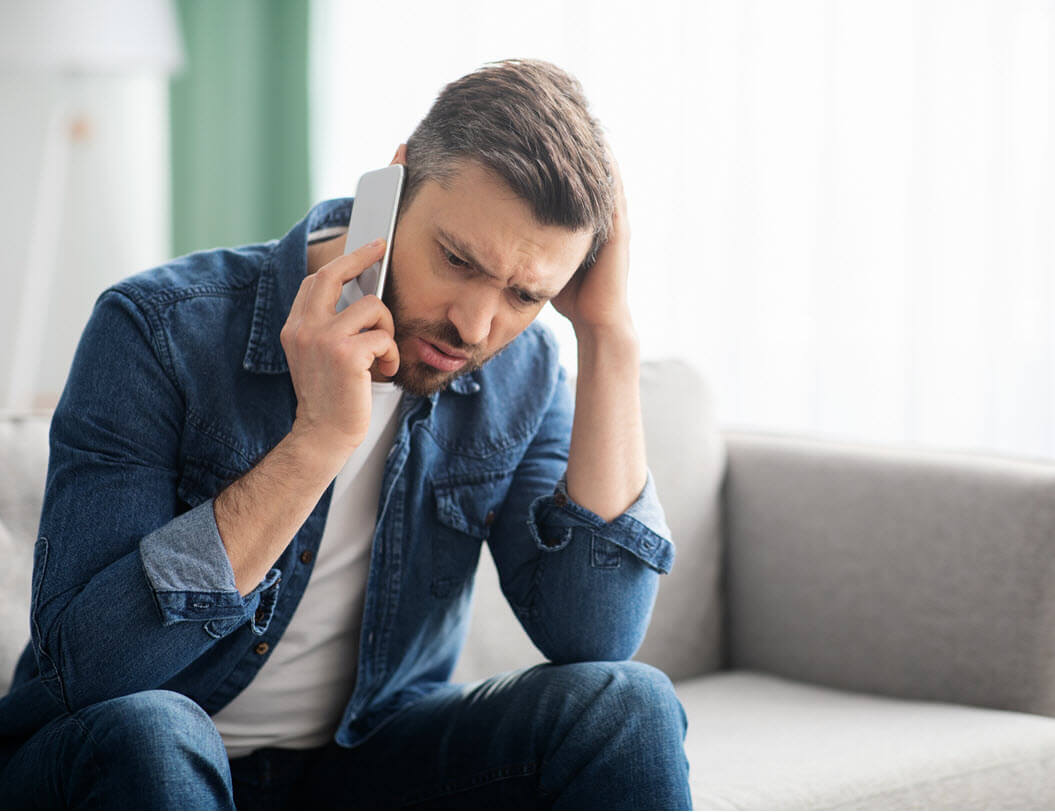 man on cell phone looking stressed