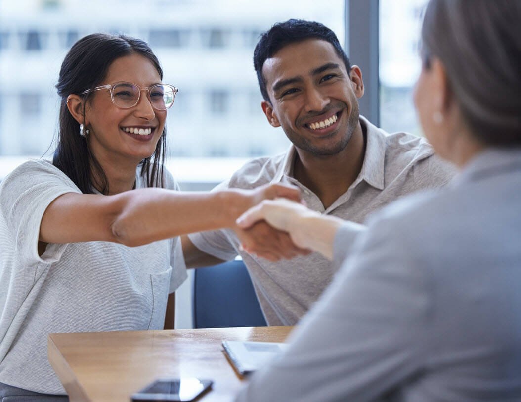 Couple in bank, shaking hands with an employee